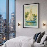 A framed art print of a sailboat on water, hung on a gray wall in a modern bedroom setting with a bed, pillows, and a large window showing a city skyline at dusk.
