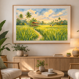 A framed landscape painting of a lush green rice field with palm trees and a small pavilion under a blue sky, displayed on a beige wall in a modern, sunlit living room with armchairs, a wooden console, and potted plants.