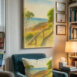 A vertical canvas painting of a coastal dune path with trees and ocean, displayed on a wall in a living room setting above a teal armchair with a matching pillow.