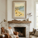 A framed coastal landscape painting hangs above a brick fireplace in a styled living room with a brown leather armchair, a beige sofa, and a woven rug.
