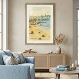 A framed beach and dock painting hangs on a beige wall in a styled living room with a blue sofa, wooden cabinet, and round coffee table.