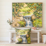 A framed landscape art print of a waterfall in a forest is displayed on a white wall above a white bench. A matching square throw pillow with the same print lies on the floor in front of the bench.